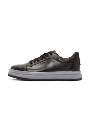 Black leather sneaker with rounded toe, lace-up design, contrasting grey midsole, textured rubber outsole, and minimalistic stitching.
