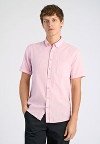Lichtroze overhemd met korte mouwen, een knoopdown kraag en één borstzak, gemaakt van een gestructureerde stof. Draagt zich met donkere broek.