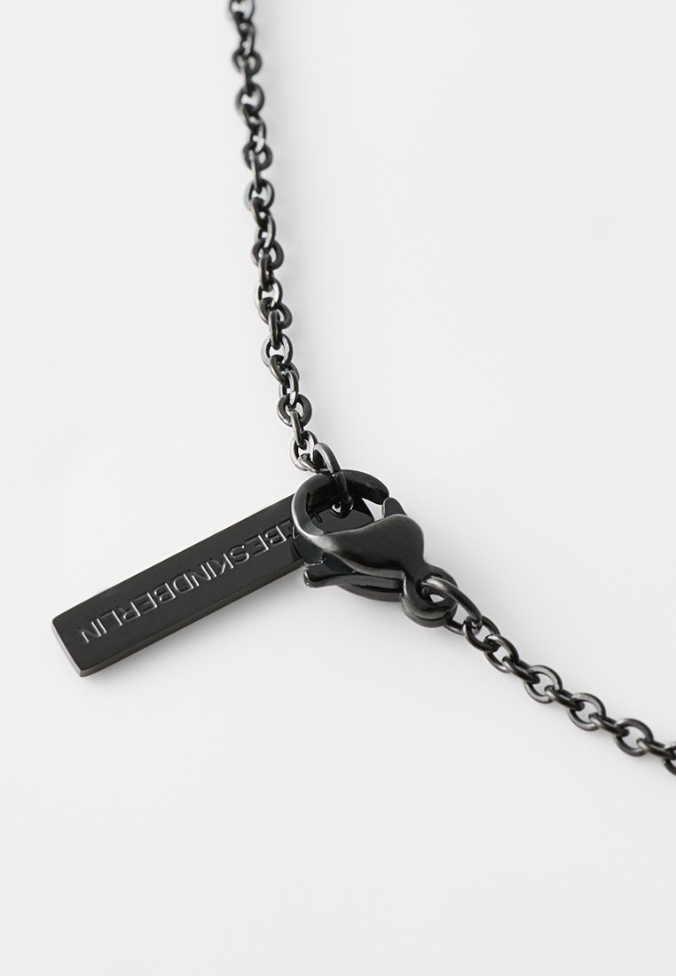 Czarny metalowy naszyjnik z delikatnym łańcuchem, z prostokątnym wisiorkiem z wybijanym napisem, zabezpieczony zapięciem.