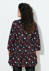 Blumenkleid mit schwarzem Hintergrund, verziert mit roten und weißen Blumen, langen Ärmeln und einem gestuften Saum, tailliertem Bund und weichem Stoff.