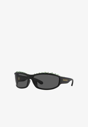 Zwarte, rechthoekige zonnebril met donkere glazen, groene kristalversieringen op het bovenste gedeelte van het montuur en het Swarovski-logo in goud op het montuurpootje.