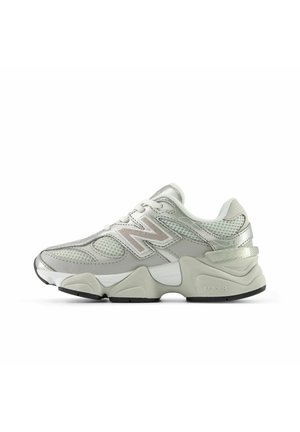 Baskets New Balance gris clair et blanc avec panneaux en mesh, semelle épaisse et logo sur le côté, vues de côté extérieur sur fond blanc.