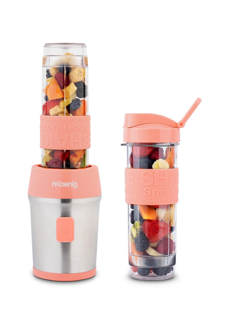 Mixeur portable H.Koenig avec base en acier inoxydable, accents en silicone rose et gobelets transparents remplis de fruits et légumes variés.