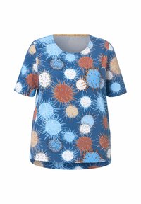 Camiseta azul de manga corta con un patrón multicolor de círculos grandes y pequeños en azul, marrón y blanco, con detalles puntiagudos.