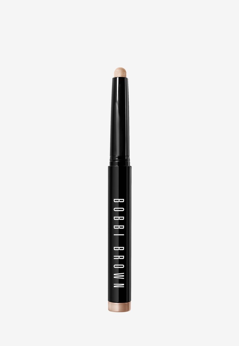 Bobbi Brown Highlighter, zylindrische schwarze Kunststoffverpackung, runder Applikator-Tip, goldene Akzentuierung am Boden, glatte Oberfläche.