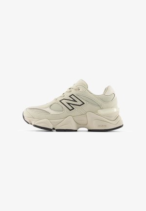 Scarpa da corsa New Balance beige con pannelli in mesh e suede, suola spessa, suola esterna nera e logo "N" sul lato.