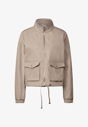 Veste cropped beige avec col montant, fermeture éclair sur le devant, deux poches poitrine et un cordon de serrage réglable en bas. Texture lisse.