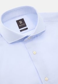 Lichtblauw kortarm overhemd van textuurstof, regular fit, klassieke kraag en twee witte knopen aan de voorkant. Merktag zichtbaar.