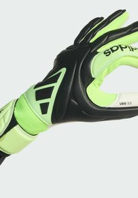 Zwarte en neon groene keepershandschoen met een textuur en ergonomisch design, voorzien van verstevigde vingers en een verstelbare polsband voor een veilige pasvorm.