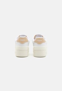 Hvite joggesko med beige detaljer, i glatt lær og teksturert stoff, tykk såle og merket hæltab.