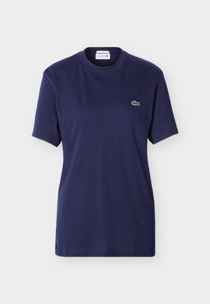 Tricou bleumarin cu mâneci scurte și decolteu rotund, cu mic logo verde Lacoste în formă de crocodil pe pieptul stâng.