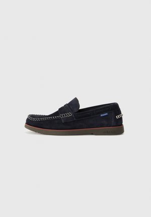 Navy suede loafers with contrasting stitching, a smooth toe box, flexible rubber sole, and a side logo tag. Classic moccasin-style design.