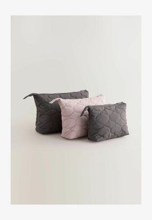 Three zipper pouches in varying sizes: dark gray and soft pink, made of quilted fabric with round stitched patterns.