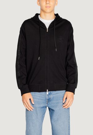 Felpa nera con zip, realizzata in un materiale morbido, dotata di tasca a marsupio, cappuccio regolabile con lacci e logo in rilievo lungo le maniche.