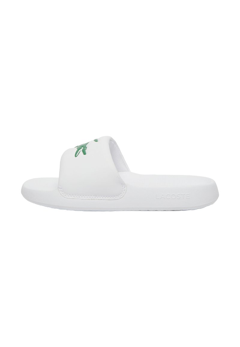 Witte slide-sandaal met een gestructureerde band, voorzien van een groen krokodillenlogo. Glad materiaal en platte zool voor comfort. Minimalistisch ontwerp.