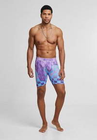 Fargerike boxershorts med rutete mønster i lilla og blått, med myk midjebånd og tett passform. Materialet ser ut til å være elastisk.