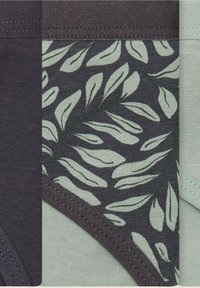 Tkanina mieszanka bawełny w ciemnozielonych i jasnozielonych odcieniach. Charakteryzuje się wzorem liści oraz kontrastowymi jednolitymi panelami z widocznym przeszyciem.