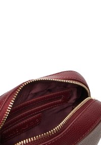 Borsa in pelle bordeaux con superficie testurizzata, cerniera dorata e interno foderato con una tasca con zip e uno scomparto aperto per l'organizzazione.