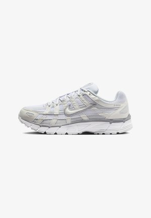 Biały i jasno szary but sportowy Nike P-6000 z siateczkową i syntetyczną cholewką, logo Nike swoosh i grubą, amortyzowaną podeszwą, pokazany z profilu.