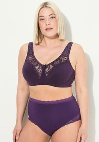 Ensemble de lingerie violet comprenant un soutien-gorge à panneaux en dentelle avec des bretelles larges et une culotte taille haute assortie, toutes deux ornées de bords en dentelle festonnés.