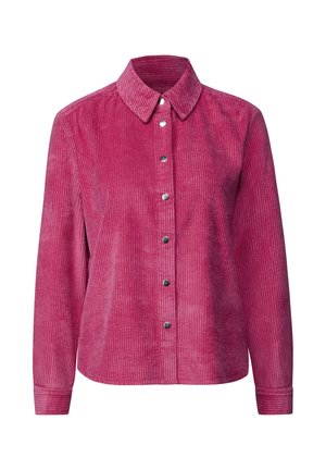 Chemise en velours côtelé rose à manches longues, avec un col et des boutons-pression sur le devant, présentant une texture à côtes verticales.