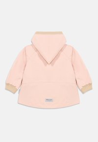Ροζ αδιάβροχο μπουφάν με κουκούλα, μπεζ ριμπ μανσέτες και στρογγυλεμένο τελείωμα. Διαθέτει μικρό λογότυπο στο πίσω μέρος. Λείο ύφασμα.