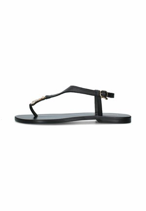 Sandalo infradito nero piatto con sottile cinturino alla caviglia e piccola fibbia dorata, con ornamento decorativo dorato sulla fascia anteriore.