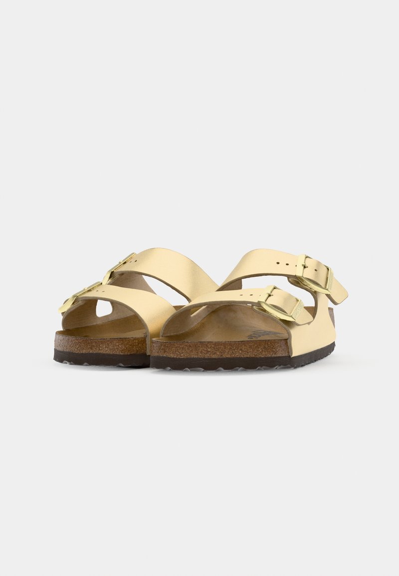 Gelbe Sandalen mit zwei breiten Riemen, verstellbaren silbernen Schnallen und Korkfußbett. Texturiertes braunes Sohlenprofil mit leichtem Grip-Muster.