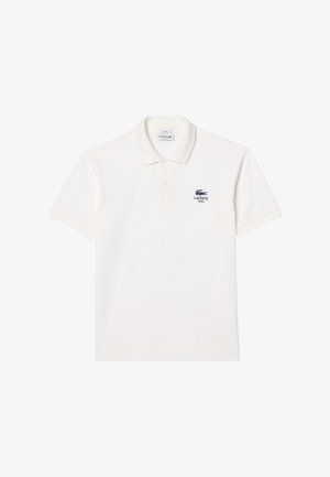 Bela bomba polo majica iz bombaža s gumbastim zapenjanjem in kratkimi rokavi. Lacoste logo v temno modri barvi na levem prsnem delu. Gladka tekstura.