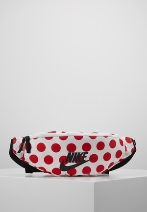 Banane Nike blanche à pois rouges, logo noir, sangle noire réglable et deux curseurs de fermeture éclair noirs.