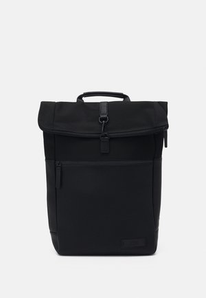 Schwarzer Rucksack aus strapazierfähigem Stoff mit einem umschlagbaren Deckel, einer vorderen Reißverschlusstasche und einem oberen Tragegriff. Glatte Textur und minimalistisches Design.
