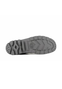 Semelle en caoutchouc gris avec surface texturée, présentant de profonds sillons pour l'adhérence et un motif en losange près du centre. Logo de la marque estampé.