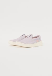 Lila slip-on cipők texturált anyagból, elasztikus pántokkal és bézs pöttyös gumitalppal. Az oldalon kis logó található.