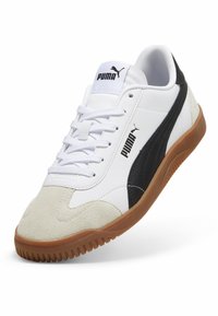 Puma sneakers med en hvid syntetisk overdel med sorte detaljer, ruskind tåhætte og en brun gummi sål med struktureret slidbane.