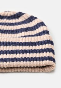 Gorro às riscas feito de tecido de malha suave, em rosa claro e azul-marinho. Apresenta uma textura ribada e uma dobra na parte inferior.