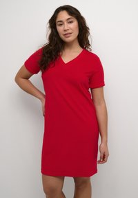 Robe t-shirt en coton rouge avec un col en V et des manches courtes roulées. Design simple avec une coupe décontractée et un accent logo subtil près de l'ourlet.