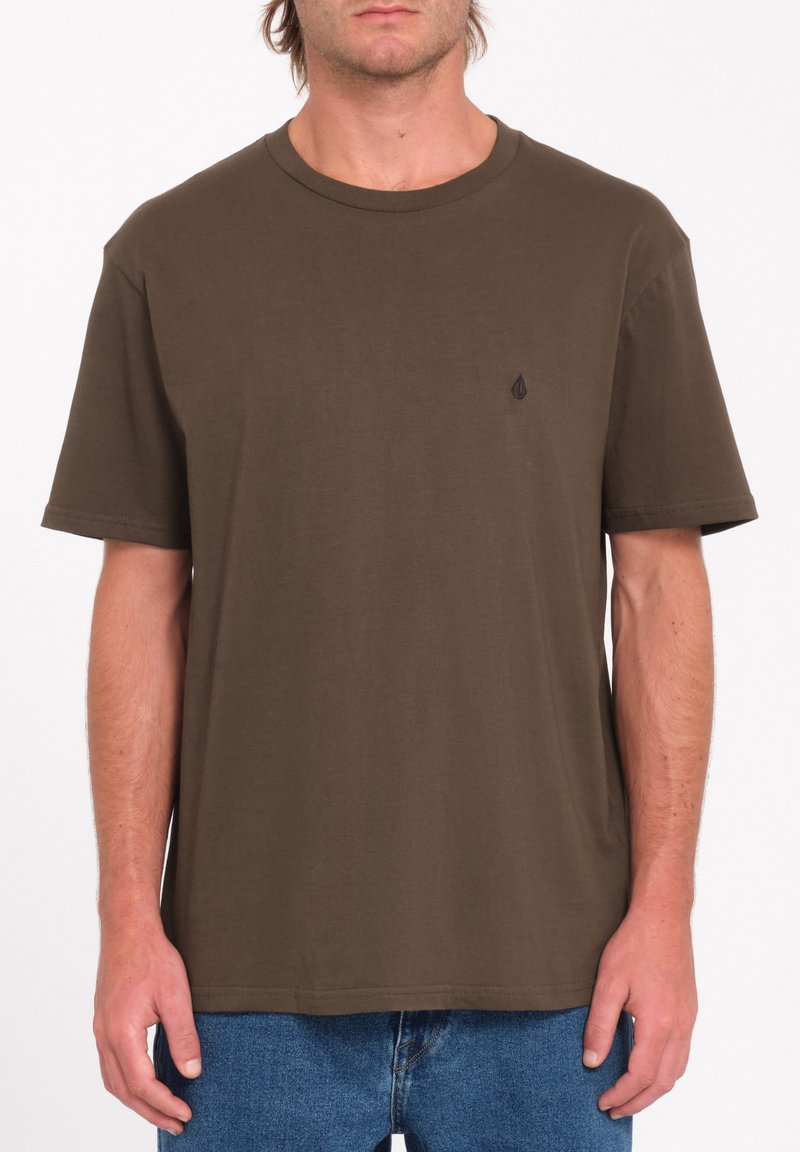 Bruine katoenen T-shirt met een ronde hals, korte mouwen en een klein zwart logo-accent op de borst. Rechte zoom.
