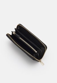 Portafoglio in pelle nera con cerniera in tono oro, dotato di più scomparti per carte, una tasca centrale con zip e fodera interna testurizzata.