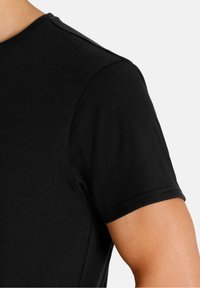 Black short-sleeve T-shirt with a smooth texture, rounded neckline, and reinforced seams. The fabric appears soft and lightweight.