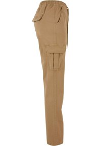 Pantalon cargo beige avec ceinture élastique, poches latérales et poche à rabat sur la cuisse, vu de profil gauche.