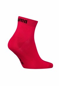 Bright red ankle sock with black "PUMA" text near the cuff, shown from the side against a white background.