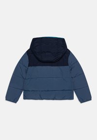 Doudoune bleu marine avec capuche, présentant une partie supérieure de couleur bleu foncé contrastante et un tissu texturé clair, conçue avec des coutures horizontales.
