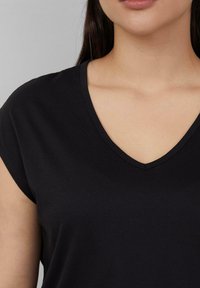 Zwarte T-shirt met korte mouwen en V-hals, gemaakt van zachte stof. Kenmerkt zich door een gladde textuur en een eenvoudige snit met minimale details.