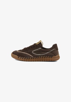 Sneaker marrone casual a taglio basso con cuciture bianche a zigzag, suola texturizzata e lacci su sfondo bianco, vista laterale.