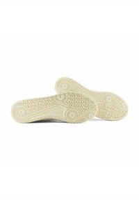 Sneaker bianchi in gomma con suole testurizzate, caratterizzate da motivi circolari e a onda per presa e trazione. Corpo liscio con bordi arrotondati.