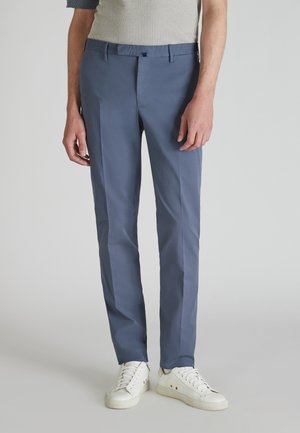Light blue trousers made of smooth fabric, featuring a straight cut, belt loops, and side pockets, paired with white sneakers.
