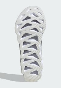 Suola della scarpa con un design ondulato e scolpito. Il materiale è gomma con una texture bianca, che mostra forme geometriche ritagliate per garantire aderenza.