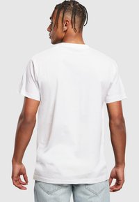 Hvid bomulds T-shirt med korte ærmer, rund halsudskæring og en afslappet pasform. Glat tekstur, uden grafik og enkel design.