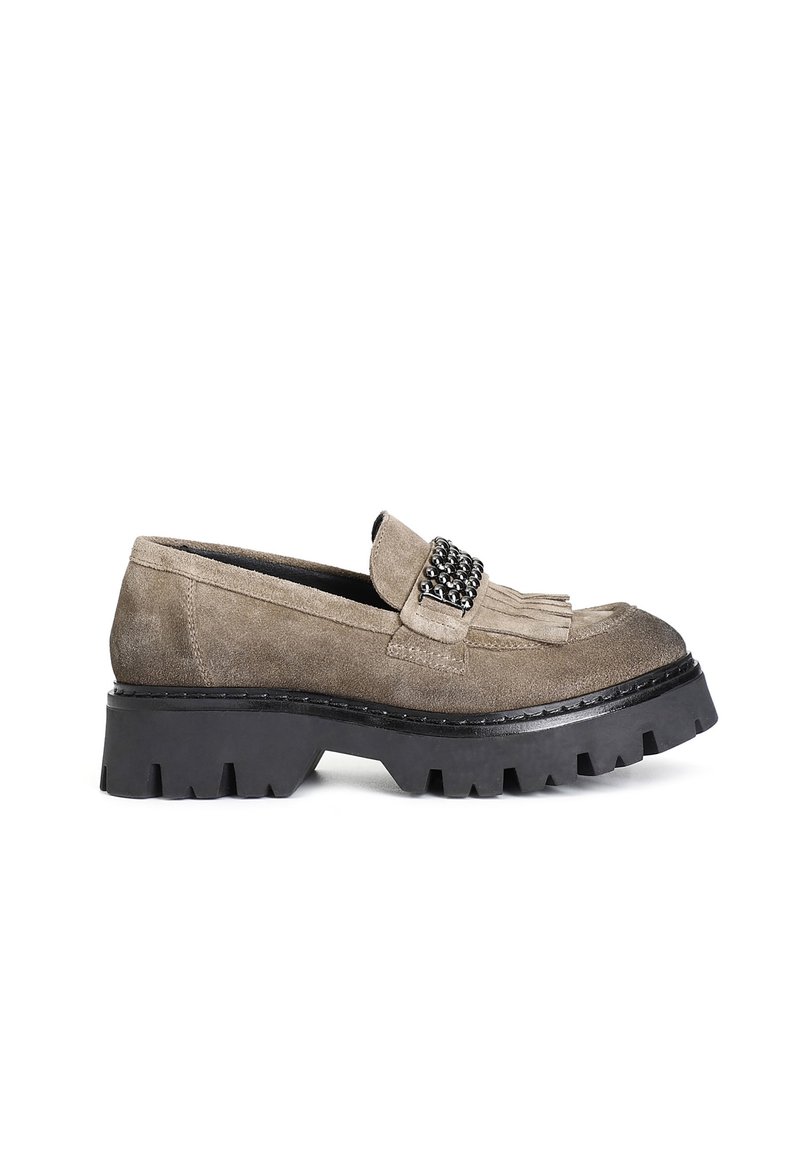 Mocassini in suede color taupe con una suola in gomma nera spessa. Presentano una frangia decorativa e una fascia decorata con dettagli metallici.
