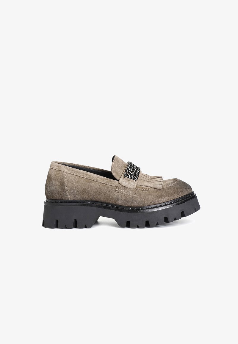Loafers din suede, în nuanța taupe, cu o talpă din cauciuc negru masiv. Prezintă o franjuri decorativ și o bandă ornamentată cu accente metalice.